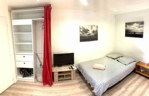 une chambre avec un lit et une télévision dans l'établissement Studio MAKATI, à Chambéry