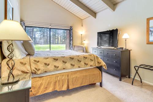 a bedroom with a bed and a tv and a window at Golf Course Getaway and Hot Tub Haven in Pinetop! in Pinetop