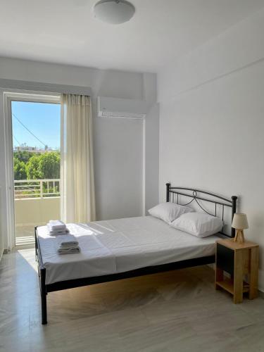 a bedroom with a bed and a large window at Nearby Sea Studio in Rethymno
