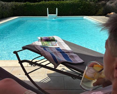 a woman sitting in a chair next to a swimming pool at Gribouillis in Cahors