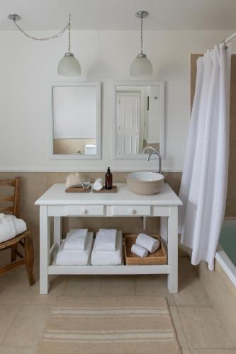a white bathroom with a sink and a mirror at Estancia Cristina Lodge - El Calafate in Estancia Cristina