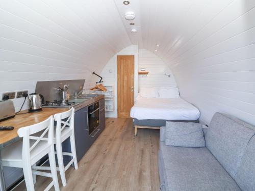 a small kitchen with a couch and a bed in a room at Starfish Rock in Bude