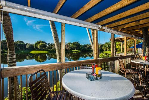 a table on a deck with a view of a lake at Trianon Bonita Bay Hotel in Bonita Springs