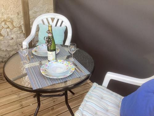 a table with a bottle of wine and glasses on it at Chez Goret Gites - Gite Skippy Couples only in Courgeac