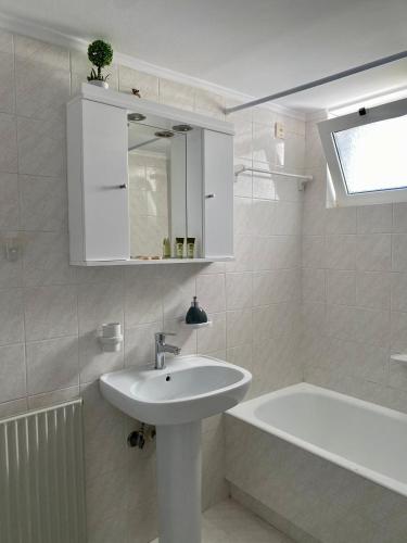 a white bathroom with a sink and a bath tub at Nearby Sea Studio in Rethymno