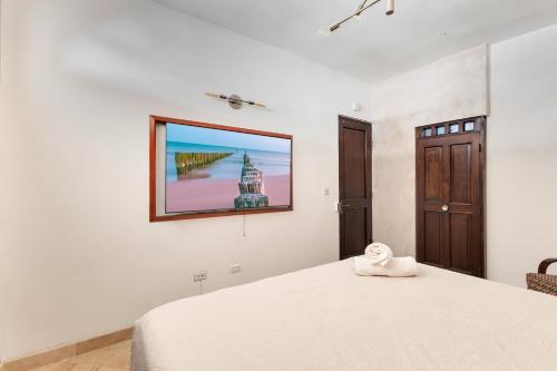 a bedroom with a bed with a picture on the wall at Casa Lucienne in San Juan