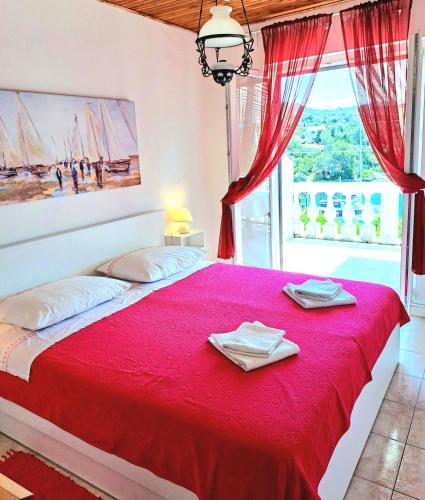 a bedroom with a large red bed with a window at Apartmani Mirko App in Molat