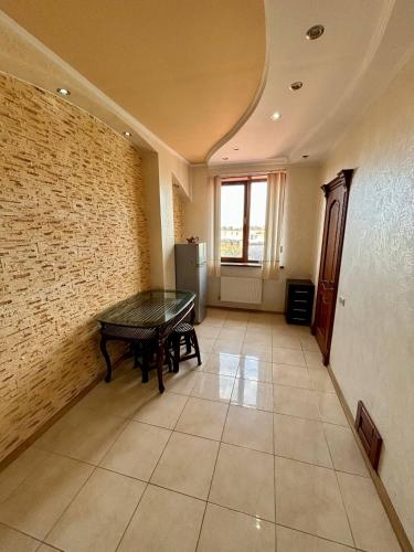 a room with a ping pong table and a brick wall at Villa Costa in Sanzhiyka