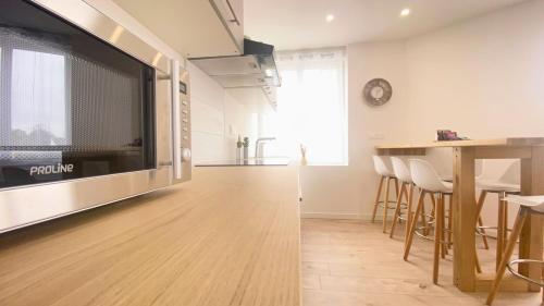 un salon avec une grande télévision et une table dans l'établissement Havre de paix au cœur de la ville, à Ay