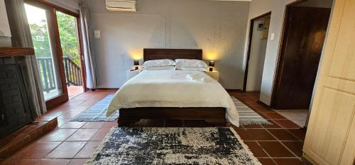 a bedroom with a bed with white sheets and pillows at Boabab at Greenway Woods in White River