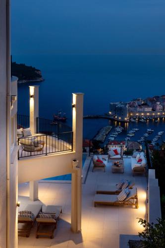 a balcony with chairs and a view of a harbor at Villa Astoria Dubrovnik in Dubrovnik
