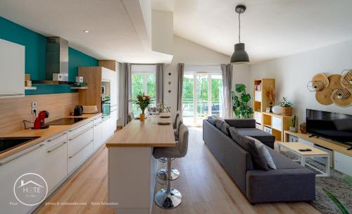 a kitchen and living room with a couch and a table at Sérénité près du Lac in Aix-les-Bains