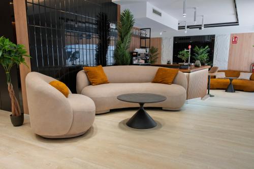 a living room with a couch and a table at Hotel Mefolinkel Suits in Lloret de Mar