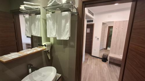 a bathroom with a sink and a toilet and a mirror at Casino Motel Senator in Gevgelija