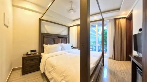 a bedroom with a large bed with a mirror at The Tanisi Hotels and Resorts, Candolim in Candolim