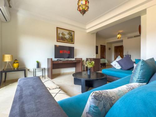 马拉喀什Elegant 2-BR, Pool And Parking Hivernage Centre的客厅里有一张蓝色的沙发和一张桌子
