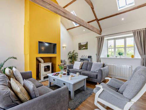 a living room with couches and a tv at 2 Bed in Bamburgh 90061 in Chatton