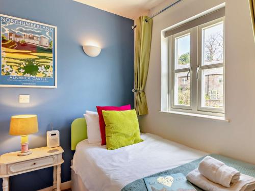 a small bedroom with a bed and a window at 2 Bed in Bamburgh 90061 in Chatton