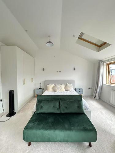 a large white bedroom with a large green bed at Spacious 4BR 4BA gated townhouse with balconies, Central JQ in Birmingham