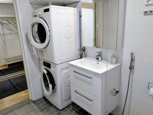 a washing machine and a sink in a bathroom at Cozy Studio Near Airport in Vantaa