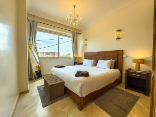 马拉喀什Elegant 2-BR, Pool And Parking Hivernage Centre的一间卧室，配有一张大床和一扇窗户。