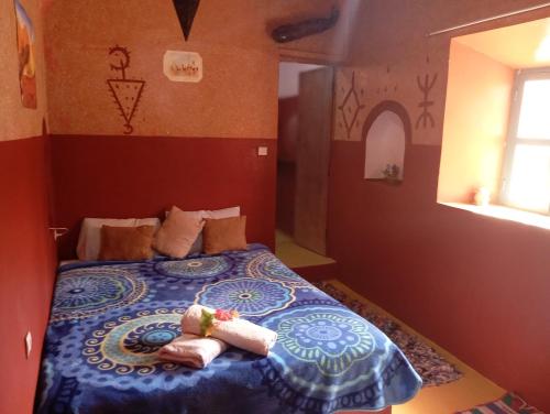 a bedroom with a bed with two towels on it at Kasbah tifaoute ait Ben haddou in Aït Ben Haddou