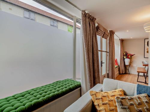 a living room with a green couch and a window at 3 Bed in Fakenham 90681 in Fakenham