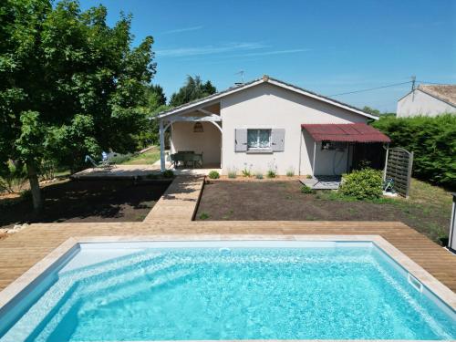 une piscine devant une maison dans l'établissement Charmante maison avec piscine au cœur des vignes, à Saint-Philippe-dʼAiguille