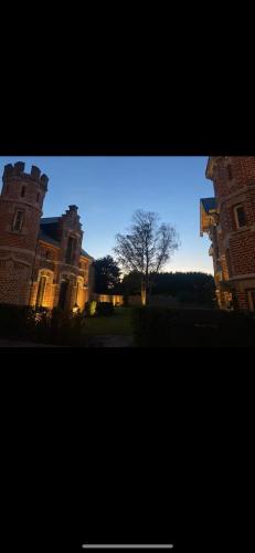 a view of a building with a tree in the distance at Les Tours de Rose - Characterful accommodation in Waremme in Waremme