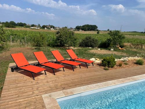 un groupe de chaises assises à côté d'une piscine dans l'établissement Charmante maison avec piscine au cœur des vignes, à Saint-Philippe-dʼAiguille