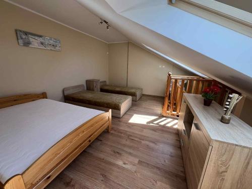 a bedroom with a large bed and a staircase at Apartament Niska 10 Krynica Morska in Krynica Morska