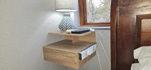 a night stand with a lamp on a wall at Acacia at Greenway Woods in White River