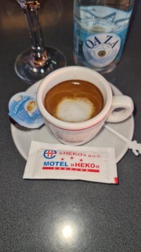 a cup of coffee on a plate with a napkin at Motel HEKO in Bugojno
