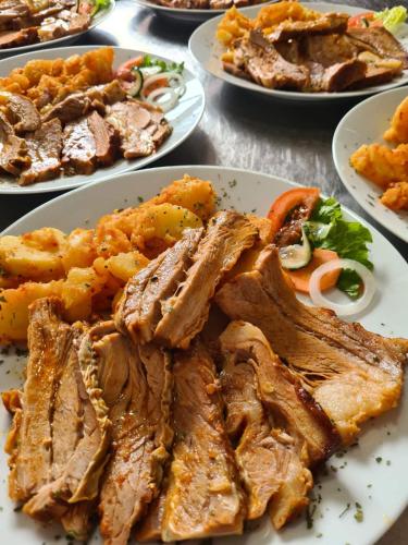 a plate of food with meat and vegetables on a table at Motel HEKO in Bugojno