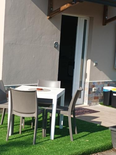 a white table and chairs on the grass at casa stefano in Piumarola