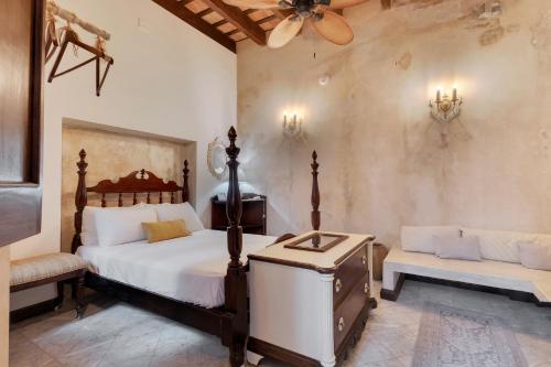 a bedroom with a bed and a couch and a fan at Casa Lucienne in San Juan