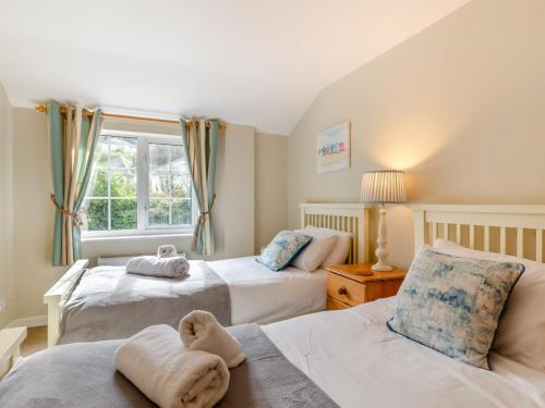 a bedroom with two beds and a window at 3 Bed in Saint Austell 95623 in Gorran Haven