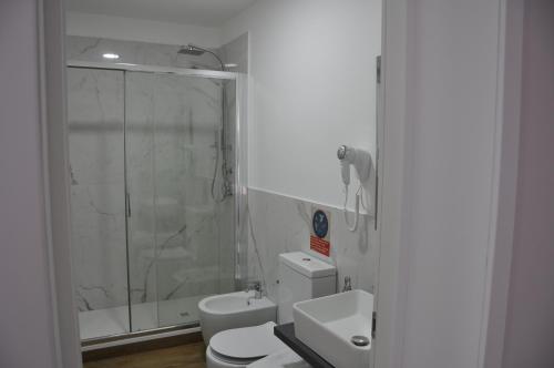 a bathroom with a shower and a toilet and a sink at Asmundo Palace Suites & Spa in Catania