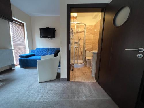 a living room with a blue couch and a bathroom at Szara Willa U Ksawerego in Szklarska Poręba