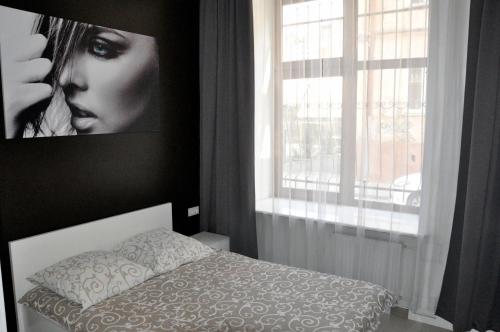 um quarto com uma cama e uma foto de uma mulher em 150 metres to Ploscha Rynok em Lviv