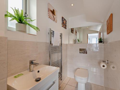 une salle de bain avec des toilettes blanches et un lavabo dans l'établissement 4 Bed in Westward Ho 94726, à Westward Ho