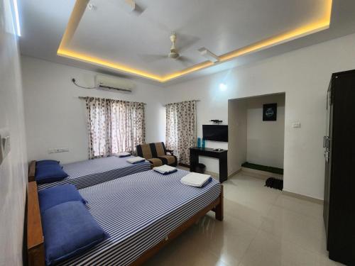 a bedroom with a large bed and a living room at Happyhomes Homestay in Trivandrum