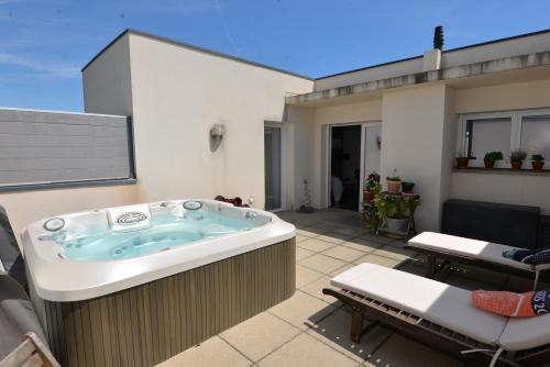 une baignoire jacuzzi assise sur un patio dans l'établissement Luxueux Duplex avec Jacuzzi, 2 chambres, 2 Lits, à Castelnau-le-Lez