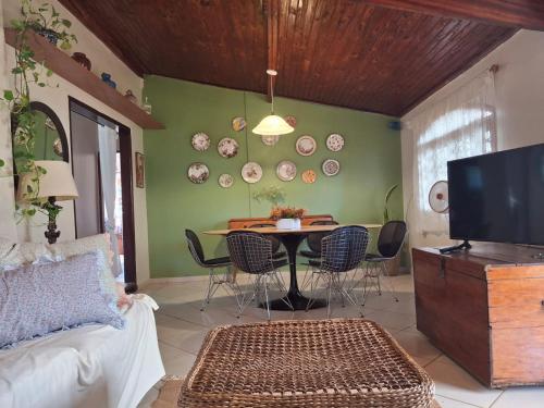 a living room with a table and chairs and a tv at Casinha Clube de Campo in Avaré