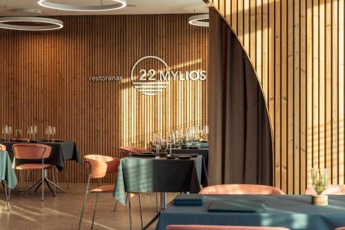 a restaurant with tables and chairs and a sign on the wall at SPA Nida in Nida