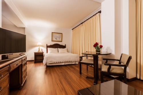 a hotel room with a bed and a table and a television at El Rey Palace Hotel in La Paz