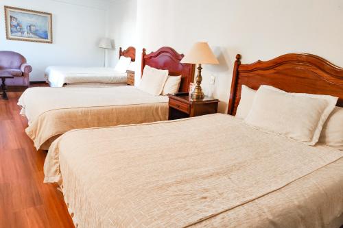 a hotel room with two beds and a lamp at El Rey Palace Hotel in La Paz