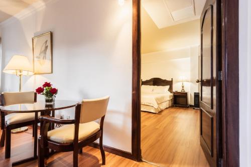 a living room with a table and a bedroom at El Rey Palace Hotel in La Paz