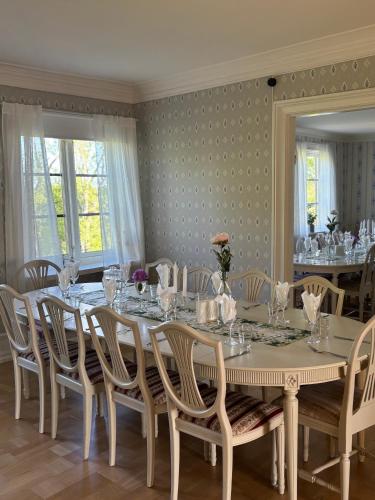 a dining room with a long table and chairs at Sjötorps Säteris 1600-tals Huvudbyggnad in Larv