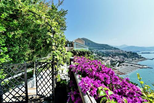 a balcony with flowers and a view of the water at In Costa Relais & Luxury Suites in Vietri sul Mare